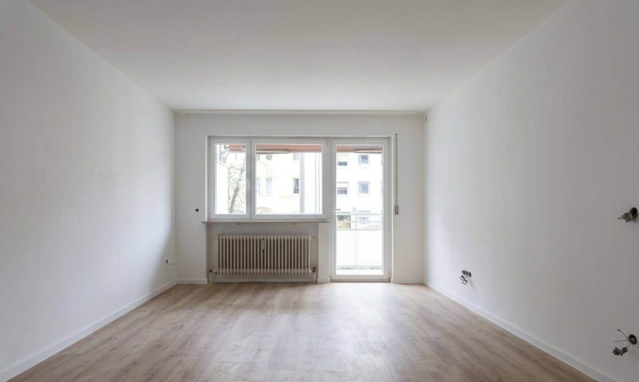 Wohnzimmer der sanierten Mietwohnung in Nürnberg St. Peter mit Zugang zum Balkon